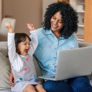 Laughing Little Girl And Mother Watching Something On A Laptop